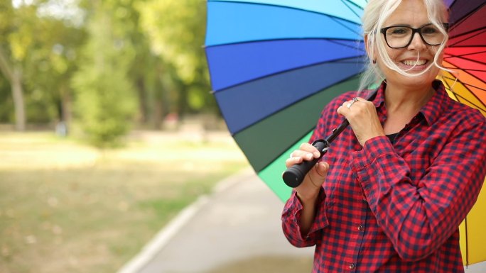 女人在户外打着彩色的伞