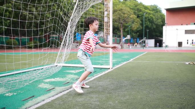 拿着足球的男孩户外活动运动跑道实时