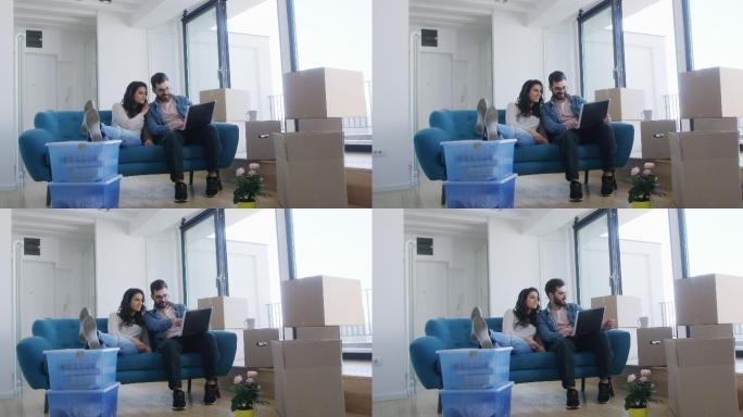 一对年轻的夫妇坐在新公寓的沙发上