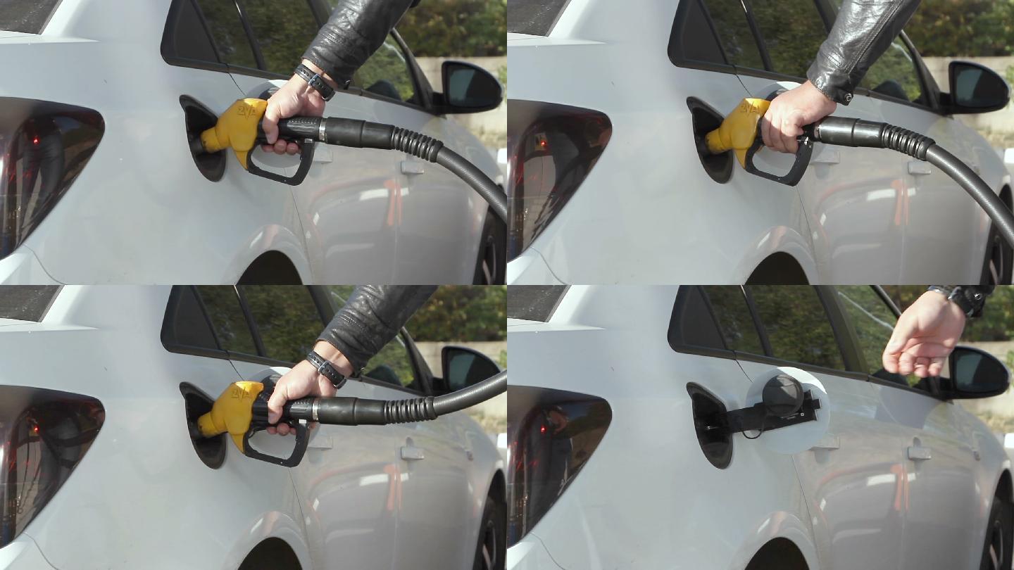 一名男子在加油站加油的特写镜头。