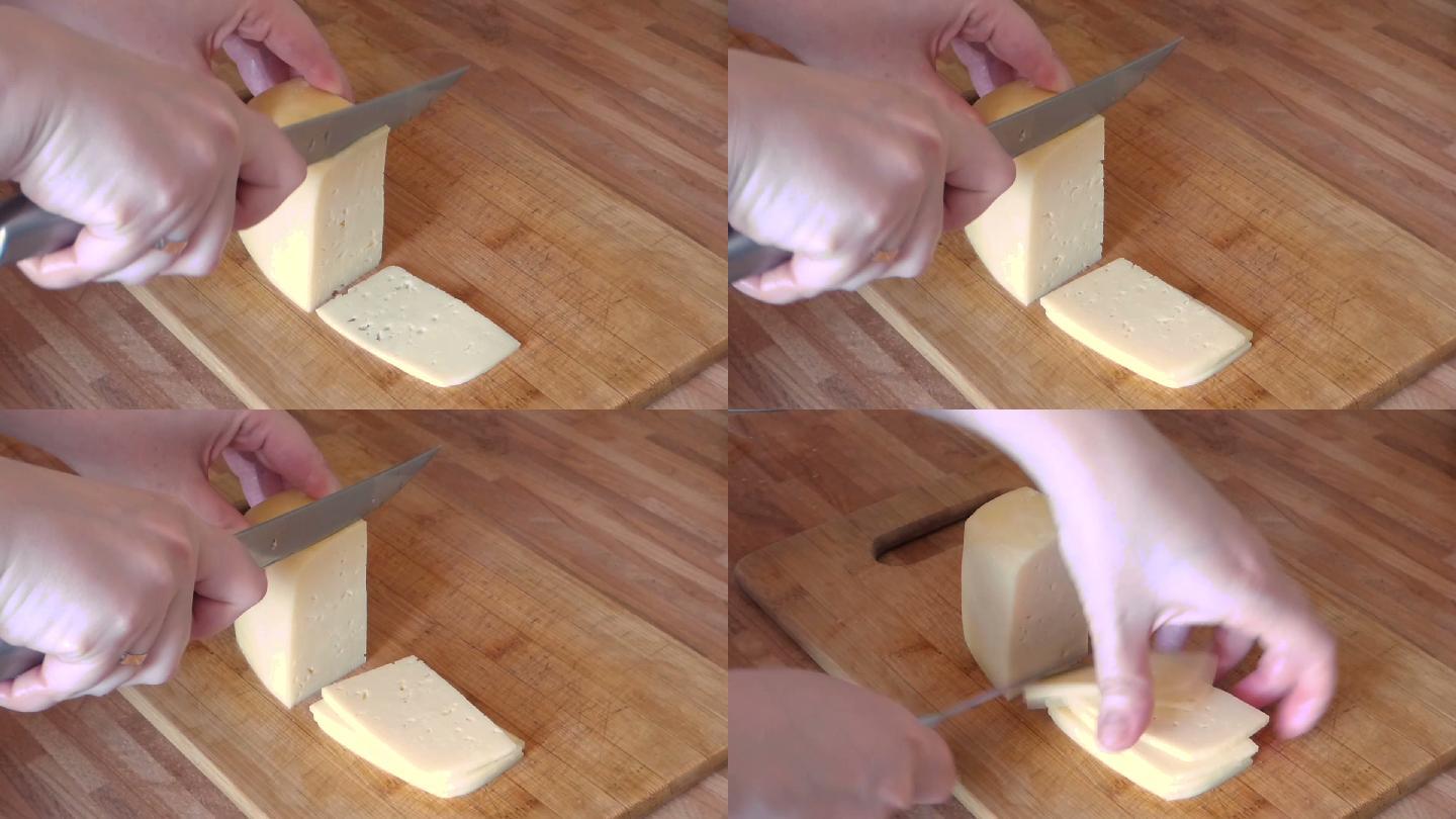 妇女用金属刀在木板切奶酪。