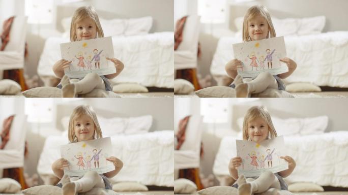 可爱的小女孩坐在枕头上展示她的绘画