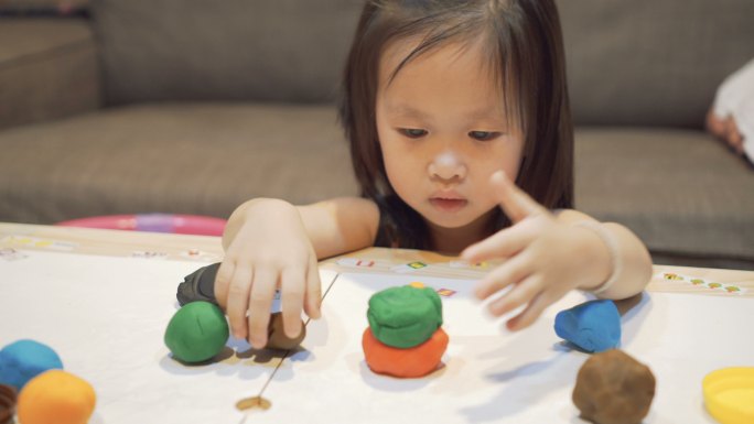 小女孩在玩粘土模型