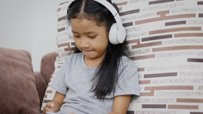 小女孩使用白色无线耳机