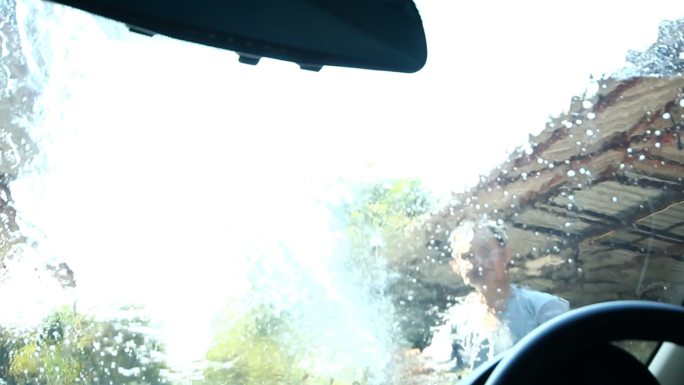 一个男人正在洗车国外外国高压水枪冲洗清洁