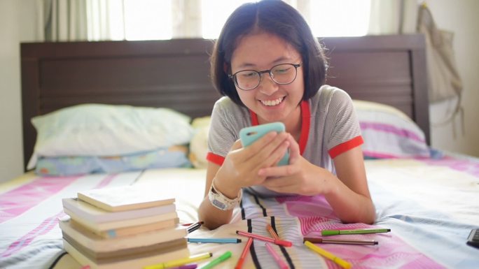 女孩使用智能手机在家里学习