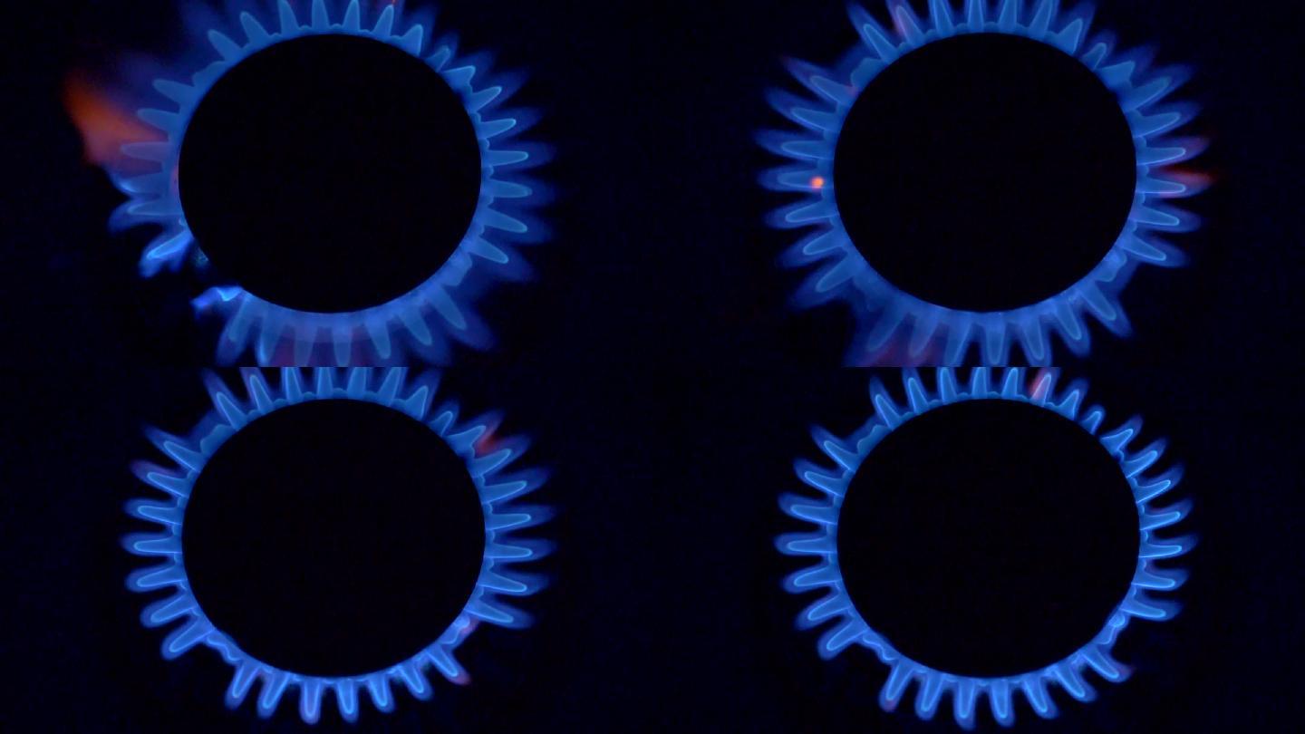 黑色背景上有蓝色火焰的煤气炉。