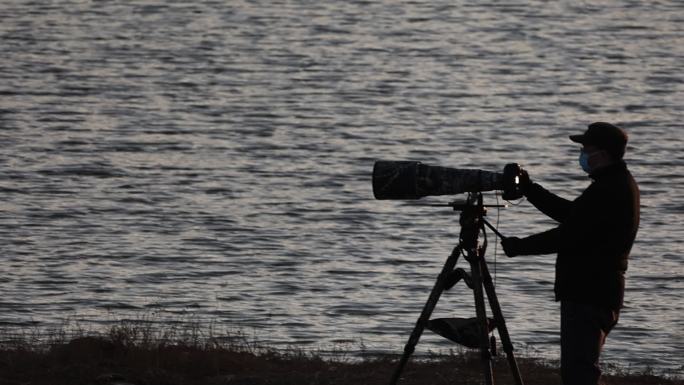 河边拍鸟的摄影师