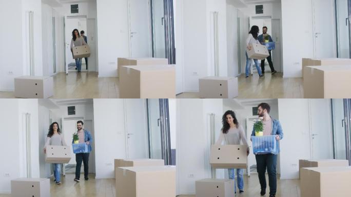 一对年轻夫妇搬着箱子搬进了新公寓
