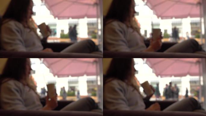 黑发女孩在咖啡馆用吸管喝饮料