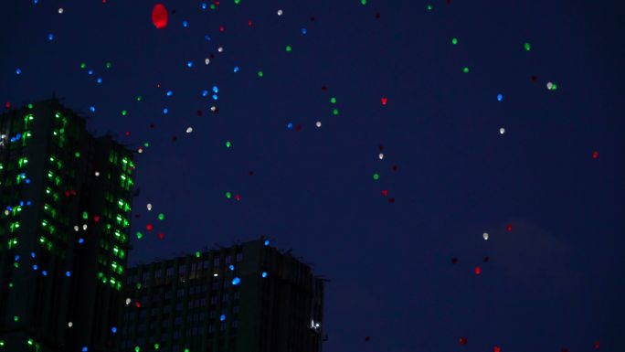 在夜晚天空中飞行的彩色氦气发光的气球