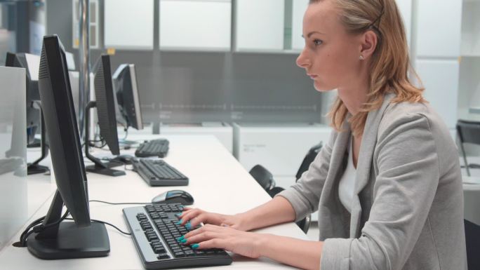 年轻的女商人在办公室里使用电脑工作。