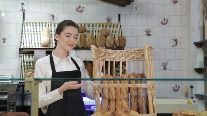 年轻微笑的面包师展示糕点女性甜点师