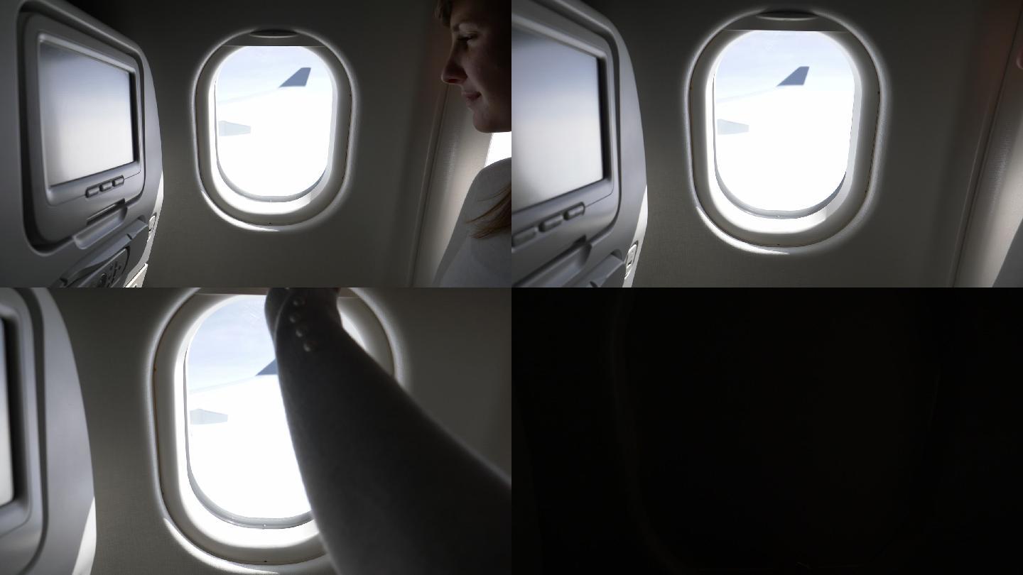 在女乘客关上遮阳板前，透过飞机窗户观看。