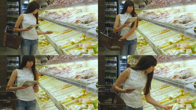 一位女士拿着购物车在超市购买冷藏食品