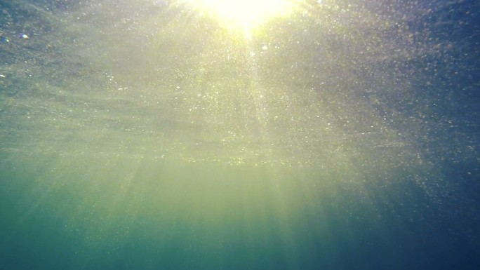阳光弥漫在水面上光照射水层金光折射粒子光
