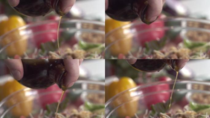 厨师用油和醋调味新鲜的田园沙拉的特写镜头