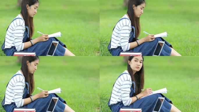 美丽的亚洲女孩在公园里读书