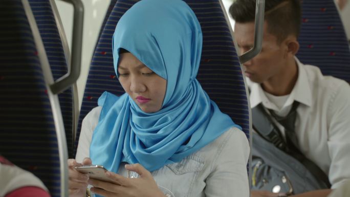 马来西亚地铁上玩手机的乘客