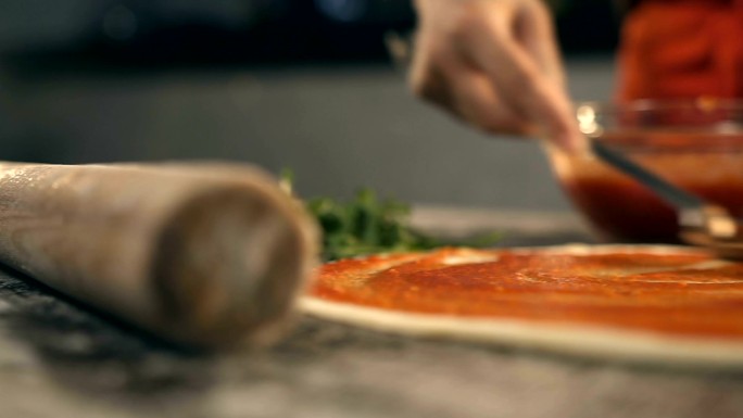 在披萨上抹番茄酱烹饪料理制作美食美味饭店