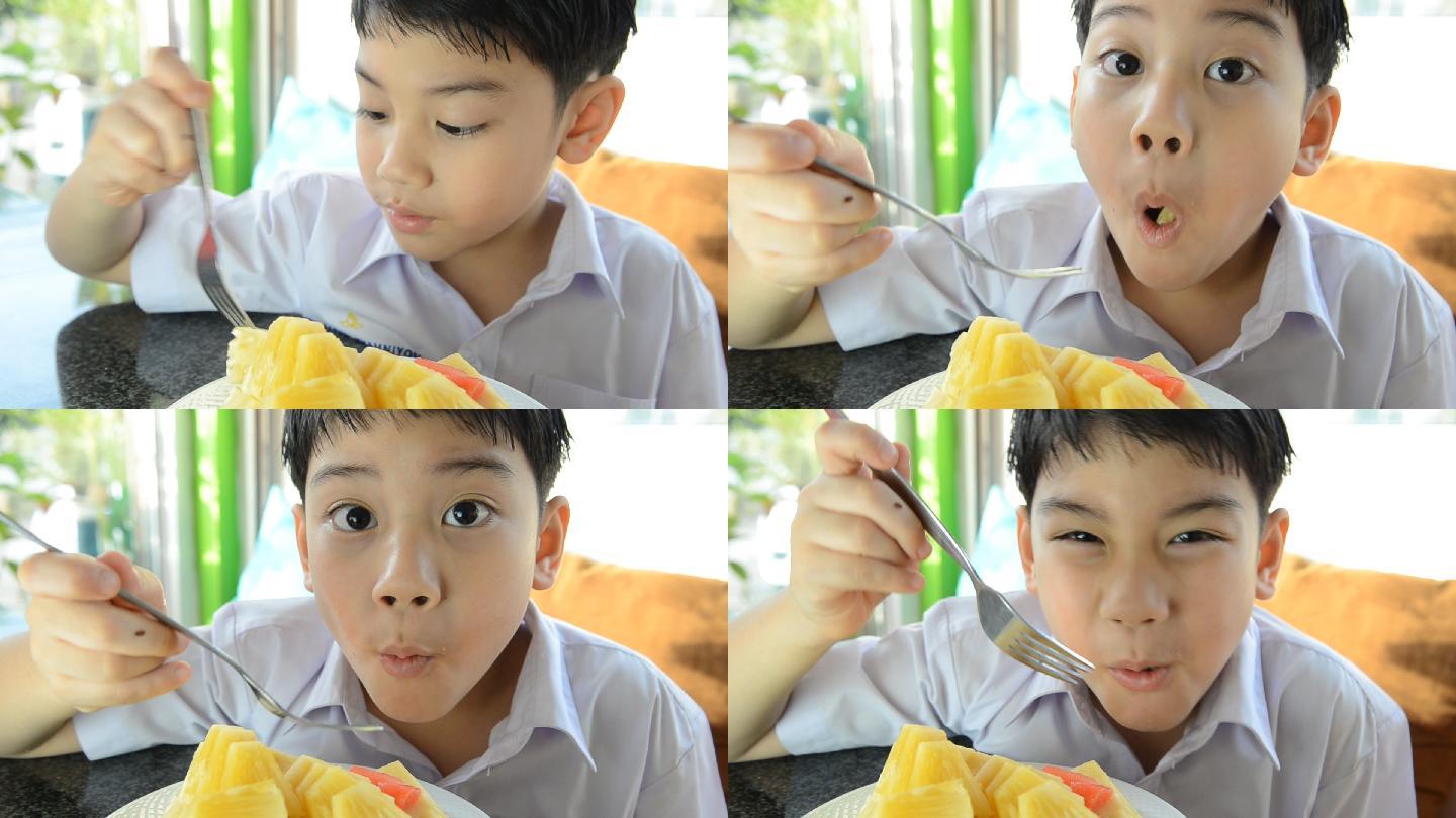 吃菠萝的小男孩。孩子儿童凤梨笑容笑脸