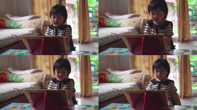 女孩在玩平板电脑小朋友看动画片开心快乐
