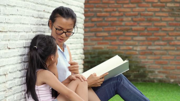 母亲和女儿一起聊天和读书