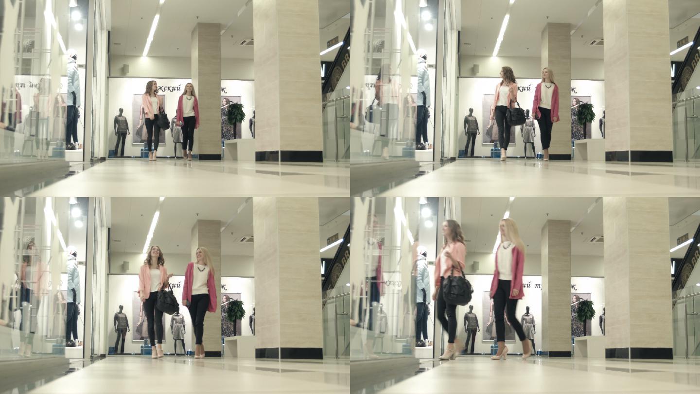 女孩们走在购物中心里，走进服装店