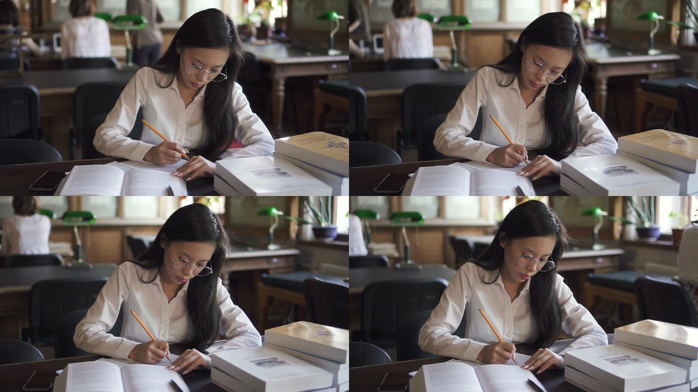 女学生穿着白衬衫在图书馆学习，做笔记