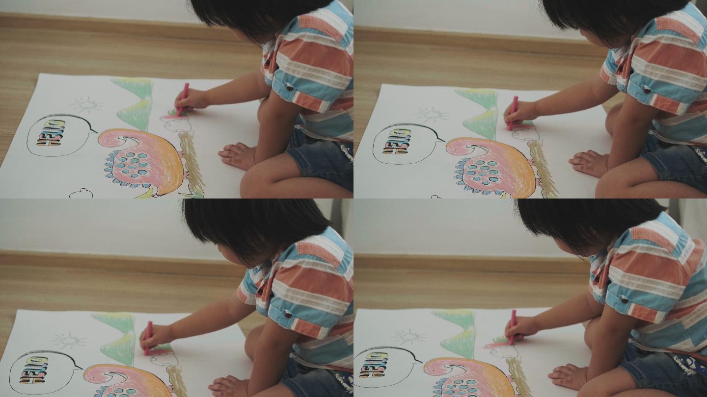 可爱的男孩正在用蜡笔画恐龙