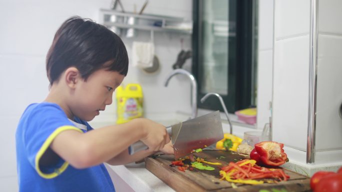 小男孩在厨房切花椰菜做饭
