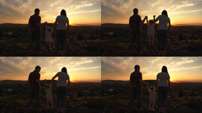 在一个夏夜的日落时分，一家人站在山上