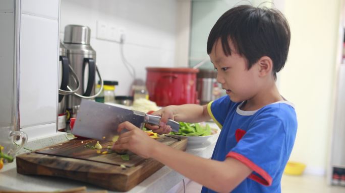 小男孩在厨房切花椰菜做饭