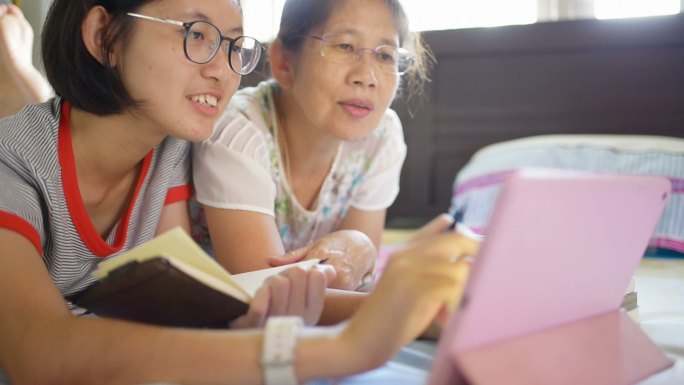 女孩使用数码平板电脑和智能手机在家里工作