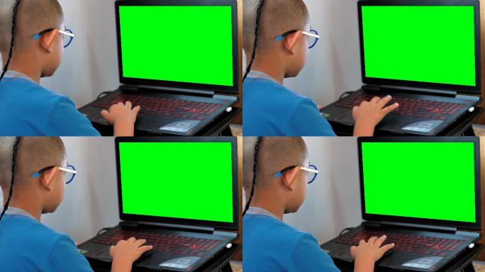 小男孩在玩绿色屏幕笔记本电脑