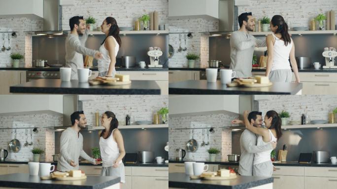 快乐的年轻夫妇在厨房跳舞