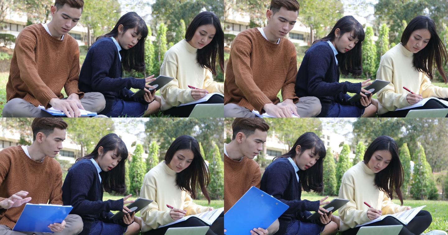 大学生在草地上一起读书