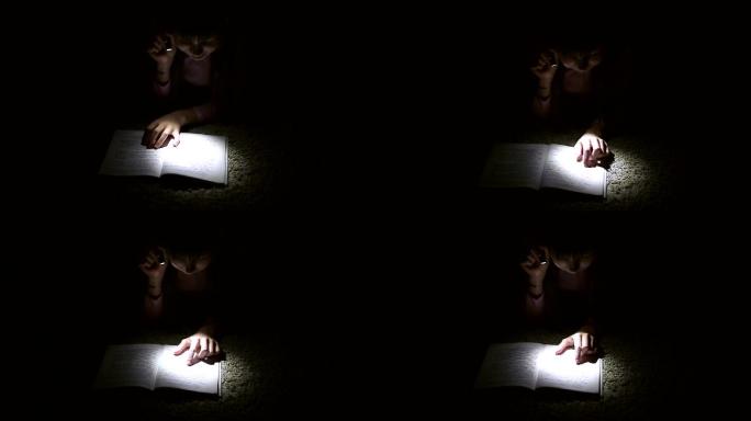 小女孩晚上在一间黑暗的房间里用手电筒看书