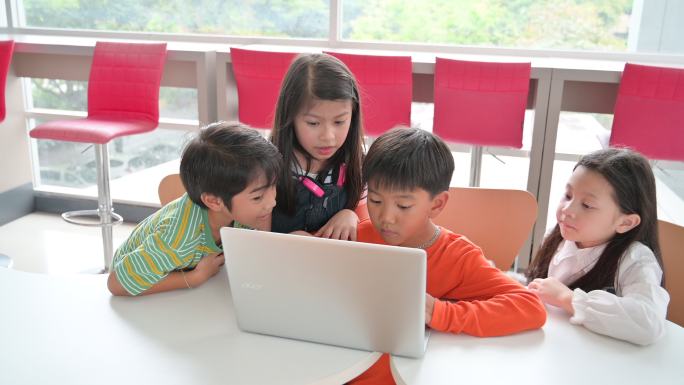 可爱的孩子们在教室里一起使用笔记本电脑