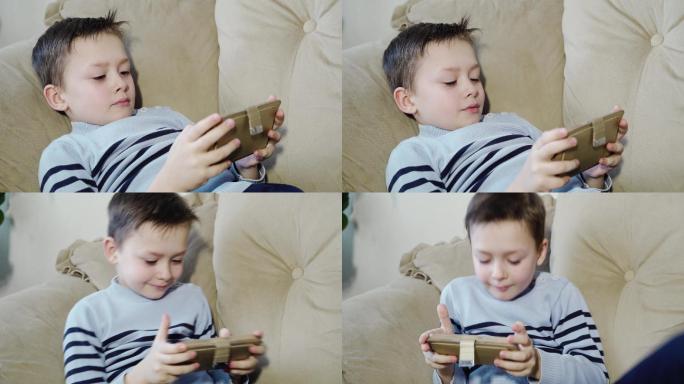 小男孩想舒服地坐在沙发上玩手机。