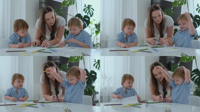 妈妈帮助两个2岁和4岁的儿子做幼儿园作业