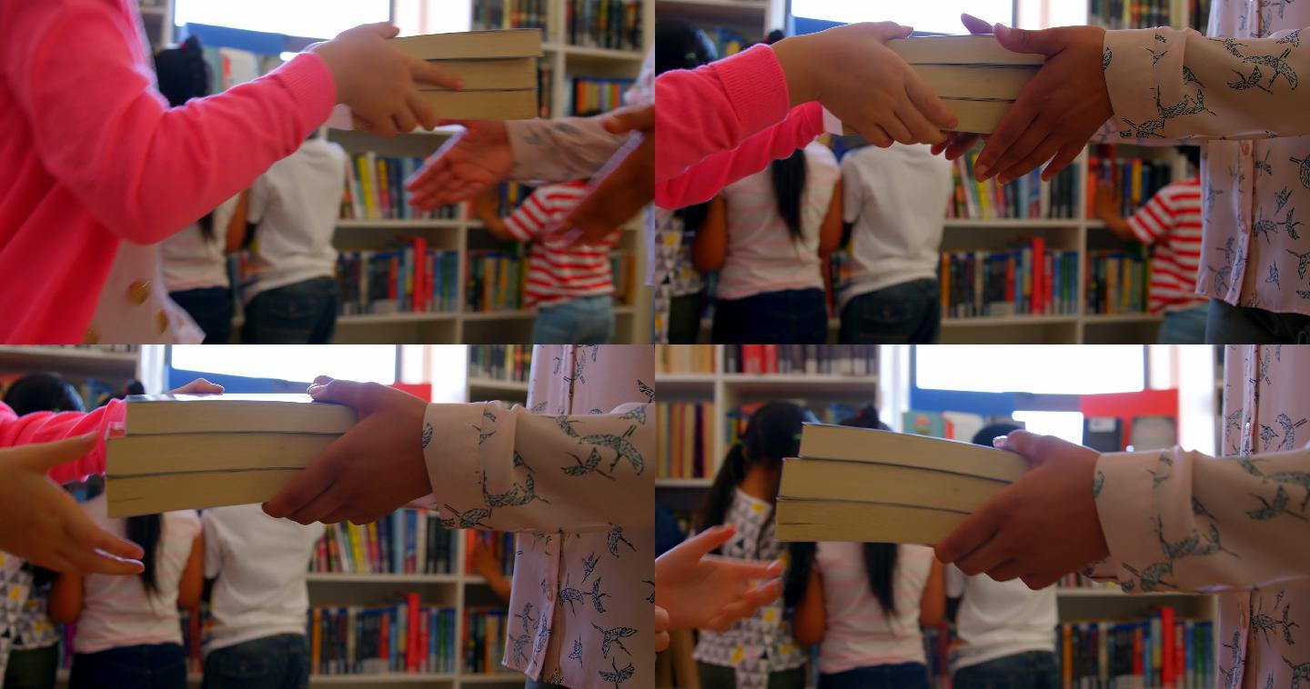 学生在学校图书馆给女老师一本书。