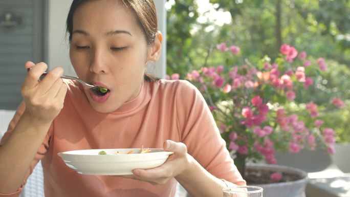 年轻女子在餐厅吃新鲜沙拉