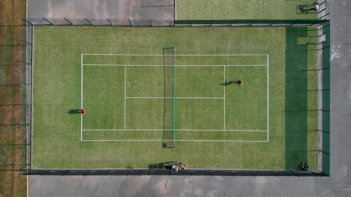 无人机在人们打球的网球场上空拍摄