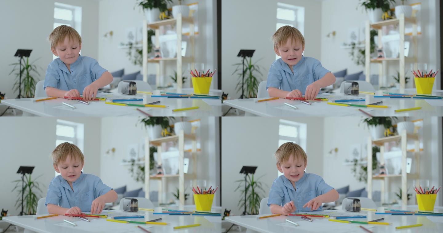 男孩坐在客厅的桌子上用铅笔在纸上画画