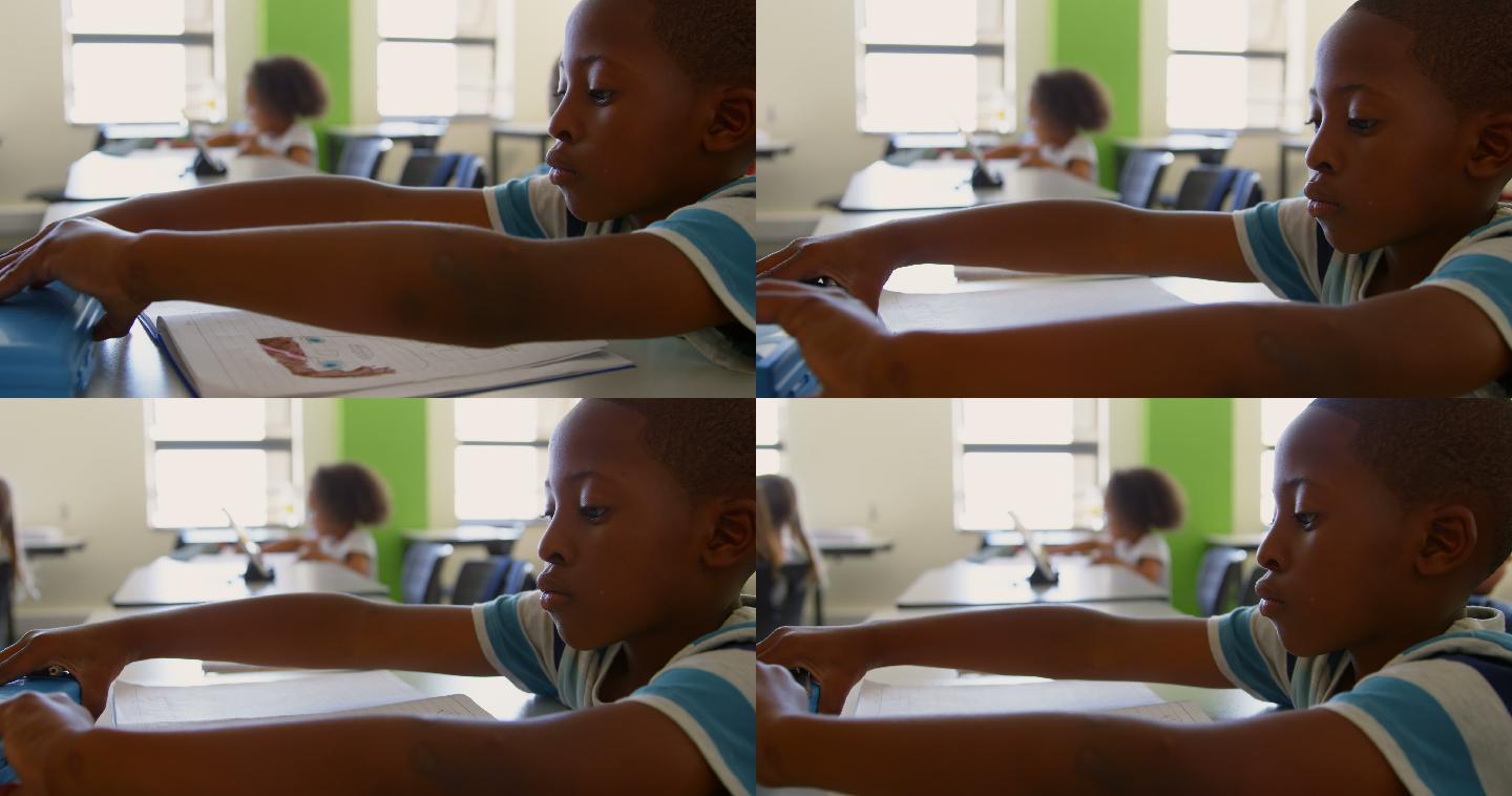 小男孩在教室打开他的铅笔盒