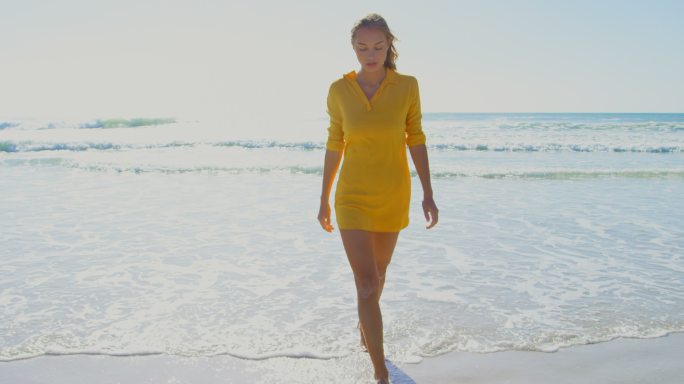 正面的女人走在海滩上
