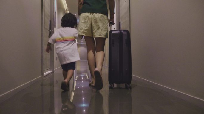年轻游客和小男孩带着行李箱离开公寓