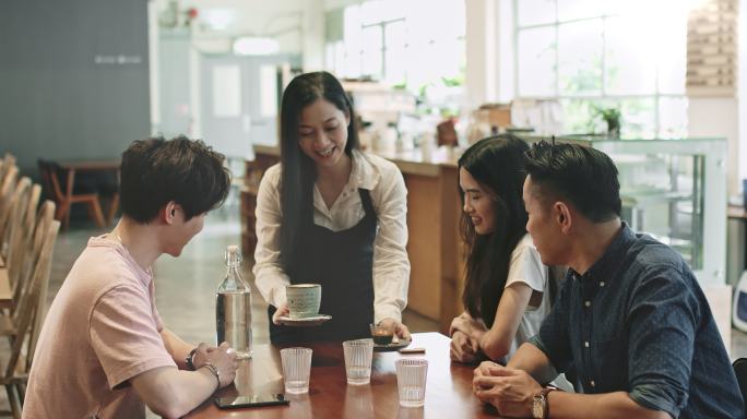 在自助餐厅为顾客提供咖啡的女咖啡师。