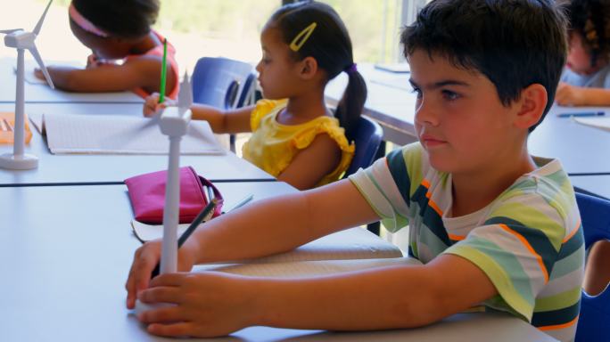 在学校的教室里，孩子在课桌上学习。